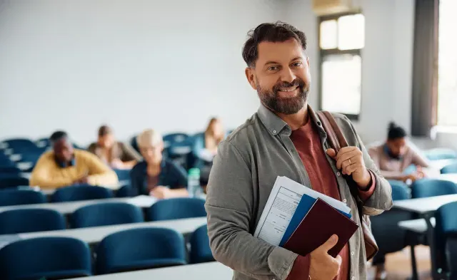 Happy mature man attending adult education training course and looking at camera.